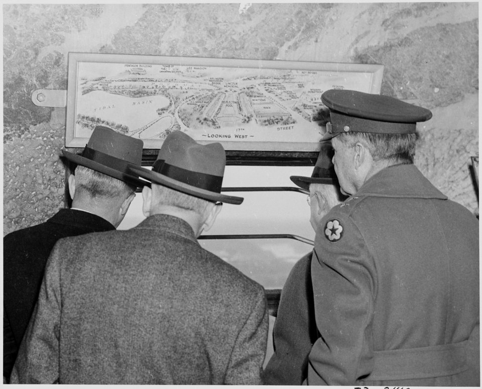 Photograph of President Truman and others with their backs turned to the camera, looking out a window near the summit... - NARA - 199297