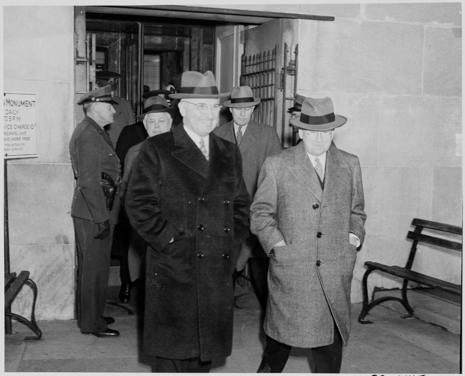 Photograph of President Truman and Secretary of the Interior Harold Ickes, with others, walking inside the Washington... - NARA - 199300