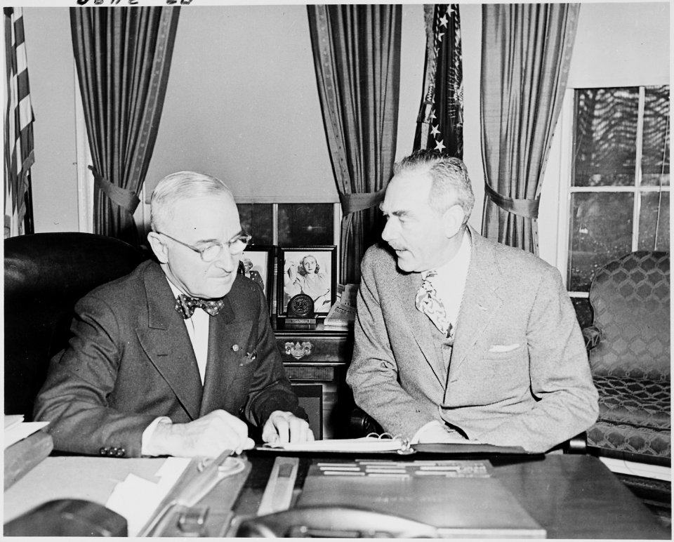 Photograph of President Truman at his desk in the Oval Office with Secretary of State Dean Acheson, discussing... - NARA - 200263
