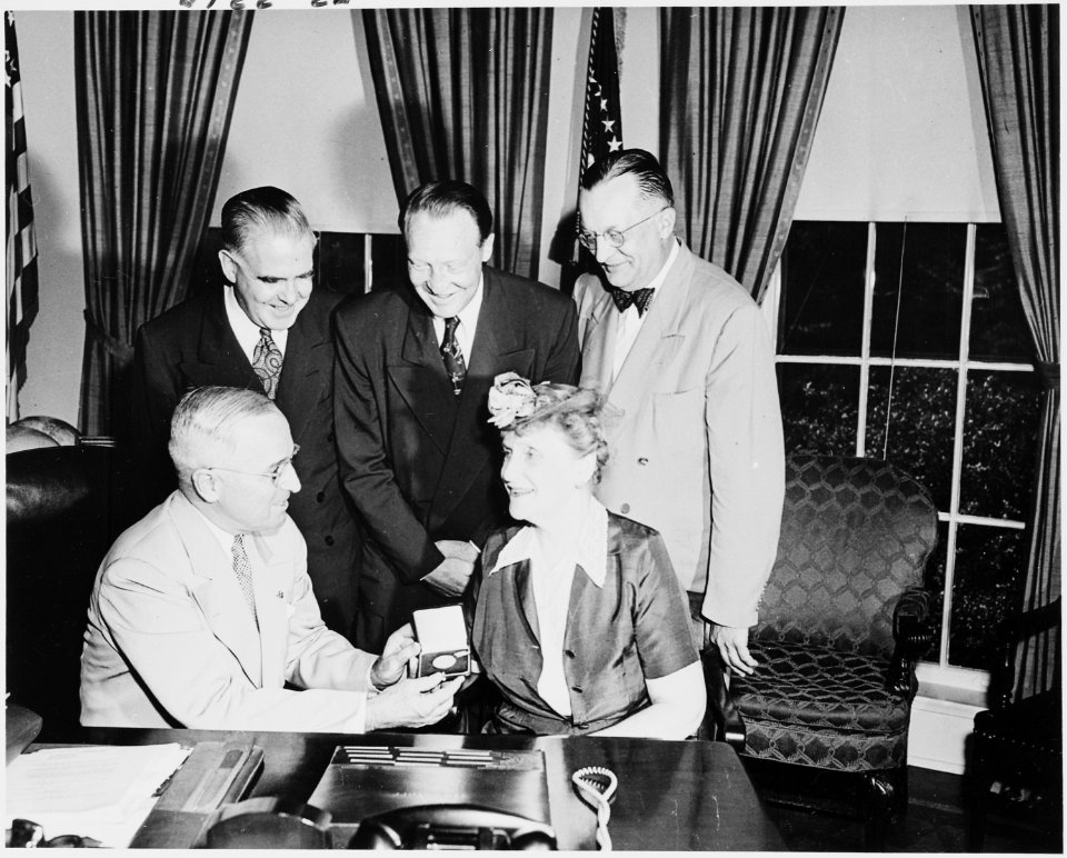 Photograph of President Truman at his desk in the Oval Office, receiving a gold commemorative medal of the National... - NARA - 200225