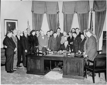Photograph of President Truman at his desk in the Oval Office, signing S. 790, an act granting the consent of the... - NARA - 200103