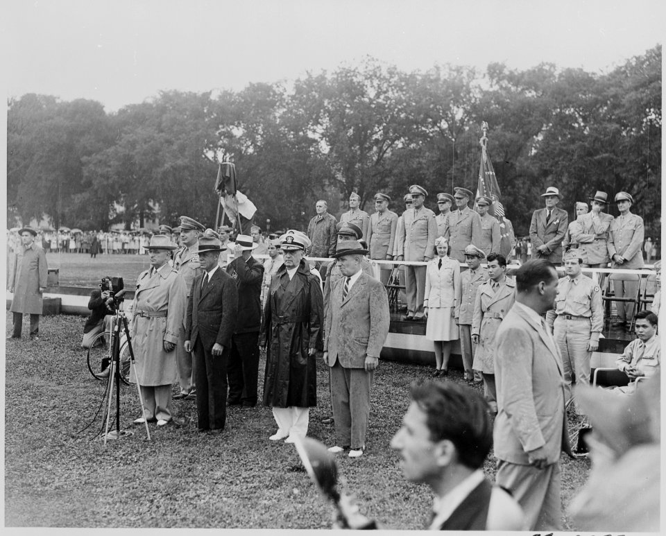 Photograph of President Truman and other dignitaries standing in the rain, reviewing the 442nd Regimental Combat... - NARA - 199388