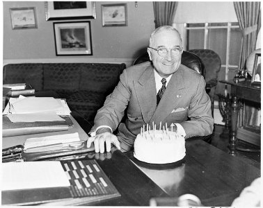 Photograph of President Truman at his desk in the Oval Office with his birthday cake, on his 67th birthday. - NARA - 200316