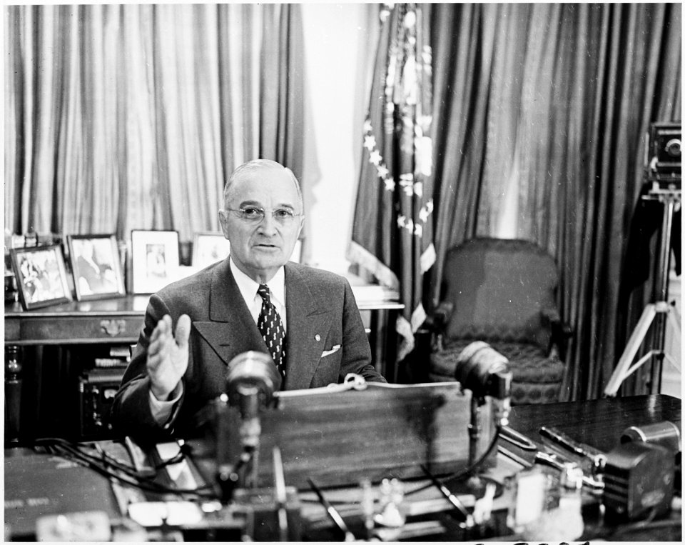 Photograph of President Truman at his desk in the Oval Office, posing for photographers on the occasion of his... - NARA - 200356