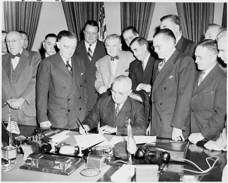 Photograph of President Truman at his desk in the Oval Office, signing S. 790, an act granting the consent of the... - NARA - 200104