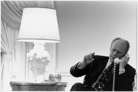 Photograph of President Gerald R. Ford Taking a Final Phone Call from Secretary of State Henry A. Kissinger, Bringing... - NARA - 186798