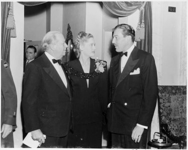 Photograph of movie stars Charles Coburn, Alexis Smith, and Cesar Romero at a Roosevelt Birthday Ball function in... - NARA - 199319 photo