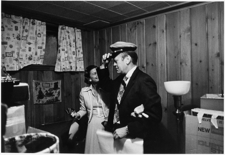 Photograph of Mrs. Betty Ford Laughing as President Ford Tries on His Old Navy Hat as They Pack for the Move to the... - NARA - 186765
