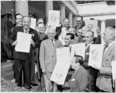 Photograph of President Truman posing outside the White House with a group of visiting cartoonists, as they exhibit... - NARA - 200158