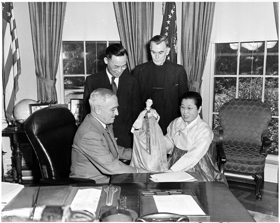 Photograph of President Truman in the Oval Office, receiving a doll from Dr. Helen Kim, a Korean educator, as Dr.... - NARA - 200314