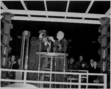 Photograph of President Truman pressing a button to light the National Community Christmas Tree during a ceremony on... - NARA - 199279