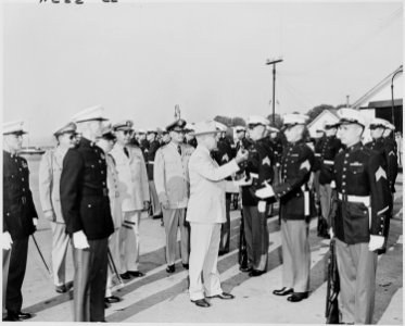 Photograph of President Truman returning a rifle to a Marine after inspecting it, as other Marines stand at... - NARA - 200215