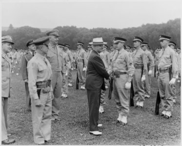 Photograph of President Truman shaking hands with with a sergeant as the military police of the District of Columbia... - NARA - 199381 photo