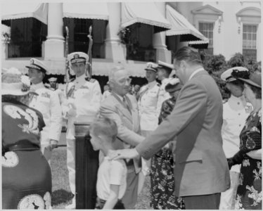 Photograph of President Truman shaking hands with guests on the White House lawn during a ceremony at which he... - NARA - 199403
