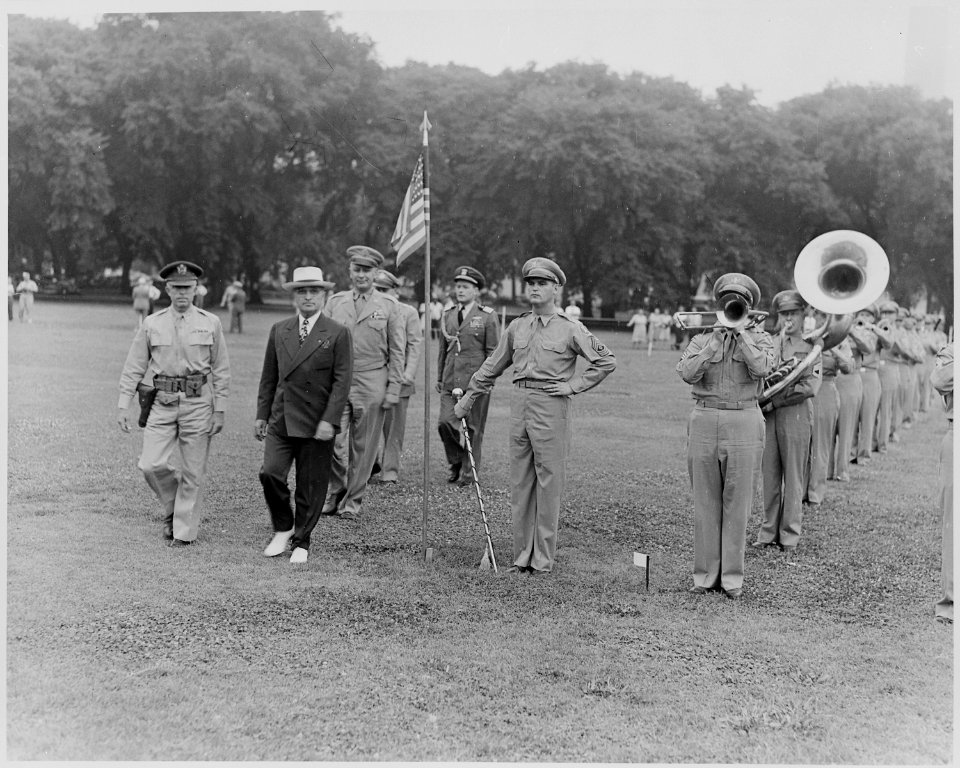 Photograph of President Truman walking past a military band that is playing on the Ellipse as he reviews the military... - NARA - 199382