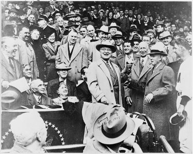 Photograph of President Truman smiling and holding up the baseball which he is about to throw out to open the... - NARA - 200100