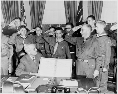 Photograph of President Truman in the Oval Office receiving a report on the accomplishments of the Boy Scouts from a... - NARA - 200293 photo