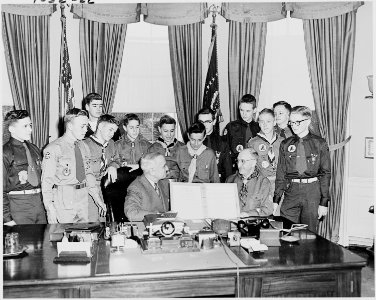 Photograph of President Truman in the Oval Office, receiving a report on the accomplishments of the Boy Scouts from a... - NARA - 200268 photo