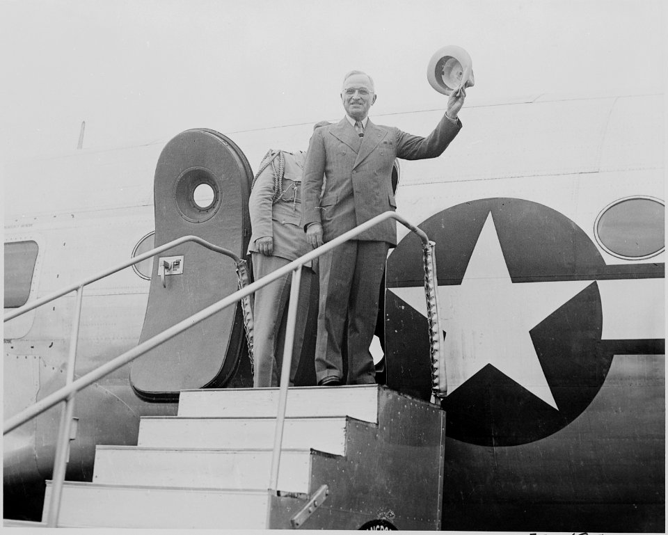 Photograph of President Truman waving his hat to spectators at the National Airport in Washington, as he prepares to... - NARA - 199135