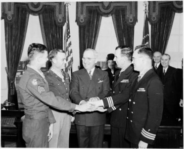 Photograph of President Truman joining hands with four servicemen he has just decorated with the Medal of Honor... - NARA - 199310 photo