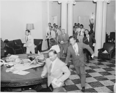 Photograph of reporters rushing excitedly through the White House with news of the Japanese surrender. - NARA - 199173