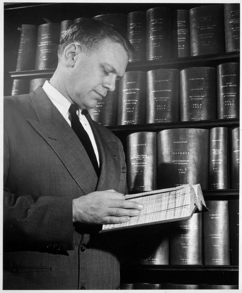 Photograph of Representative Gerald R. Ford Paging Through a Bound Copy of 1952 Congressional Hearings - NARA - 186885