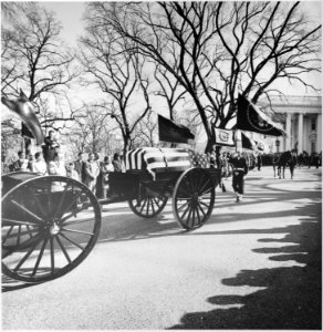 Photograph of the caisson bearing the flag-draped casket of President John F. Kennedy leaving the White House... - NARA - 200455