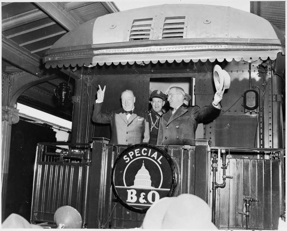 Photograph of President Truman waving his hat and Winston Churchill flashing his famous V for Victory sign from the... - NARA - 199350 photo