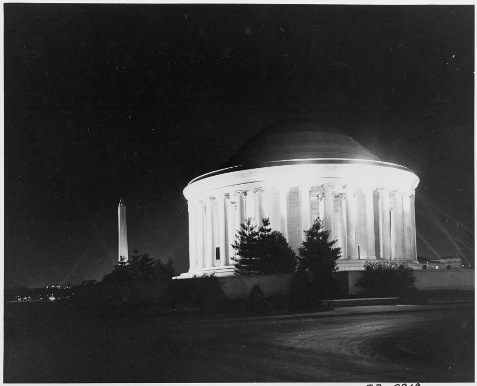 Photograph of the Jefferson Memorial, with the Washington Monument in the background, illuminated at night during... - NARA - 200070
