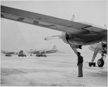 Photograph of the President's airplane on the snowy runway of Washington's National Airport, before its departure for... - NARA - 199283