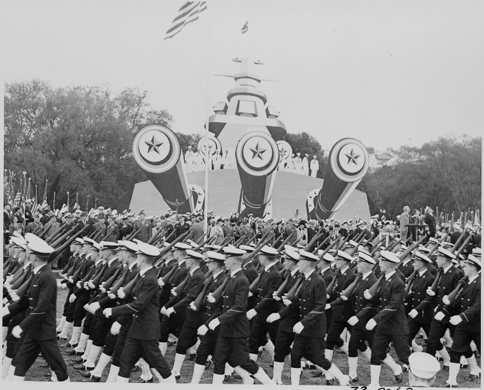 Photograph of troops marching past mock-up of battleship at ceremonies honoring Admiral Chester Nimitz. - NARA - 199216