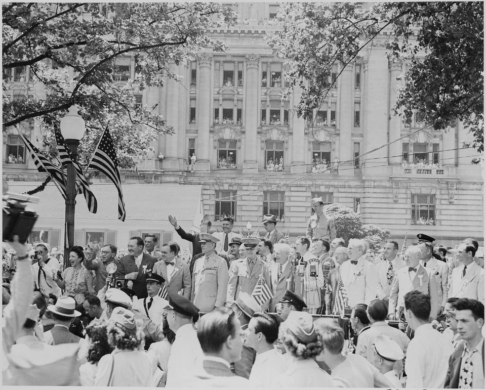 Photograph of unidentified Army officers and civilians on speaker's platform, apparently reacting to the arrival of... - NARA - 199125