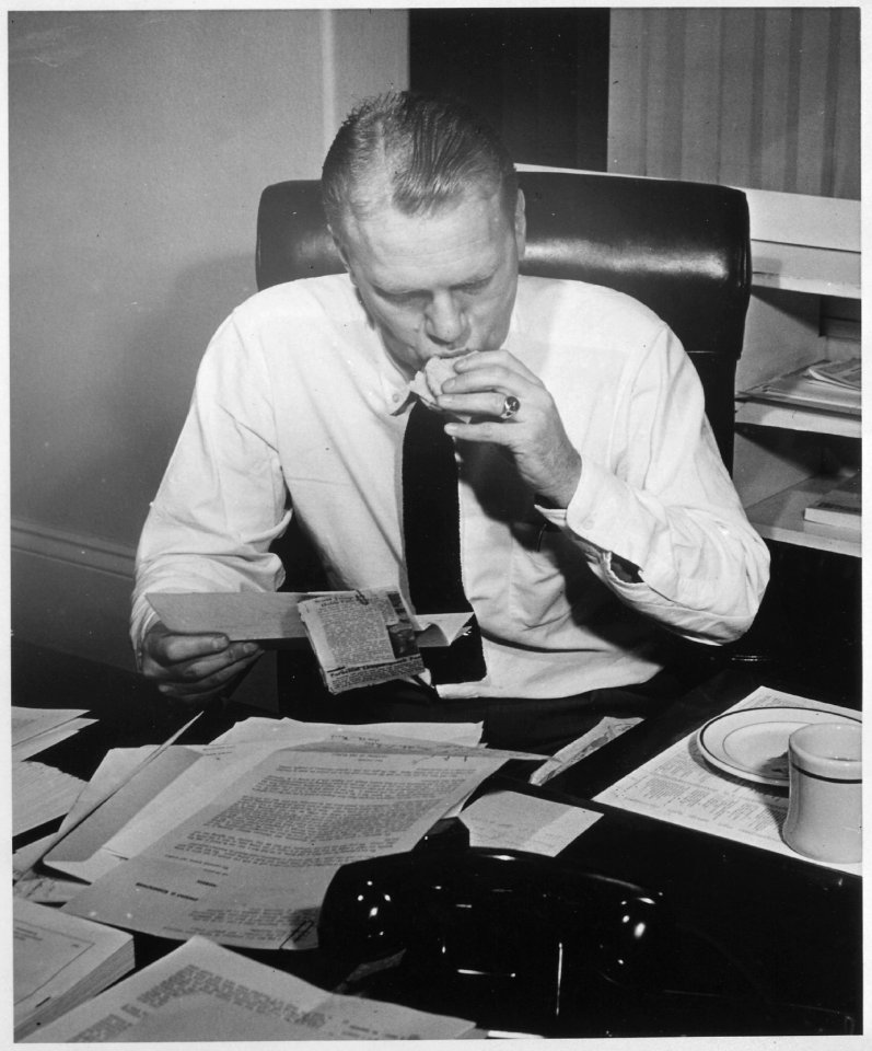 Photograph of Representative Gerald R. Ford Reading Constituent Mail While Eating a Sandwich at His Desk in His House... - NARA - 186883