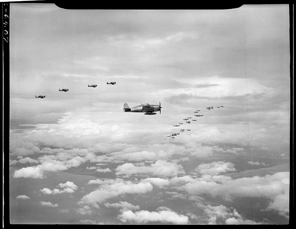Planes from USS Yorktown, CV-10, fly in formation high above clouds. F6F's and TBF's (in distance). - NARA - 520945