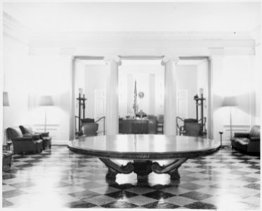 Photograph of the reception area in the White House, with receptionist William Simmons at his desk. - NARA - 199478 photo