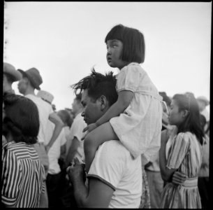 Poston, Arizona. A little evacuee of Japanese ancestry gets a ride on her father's shoulders. - NARA - 538555