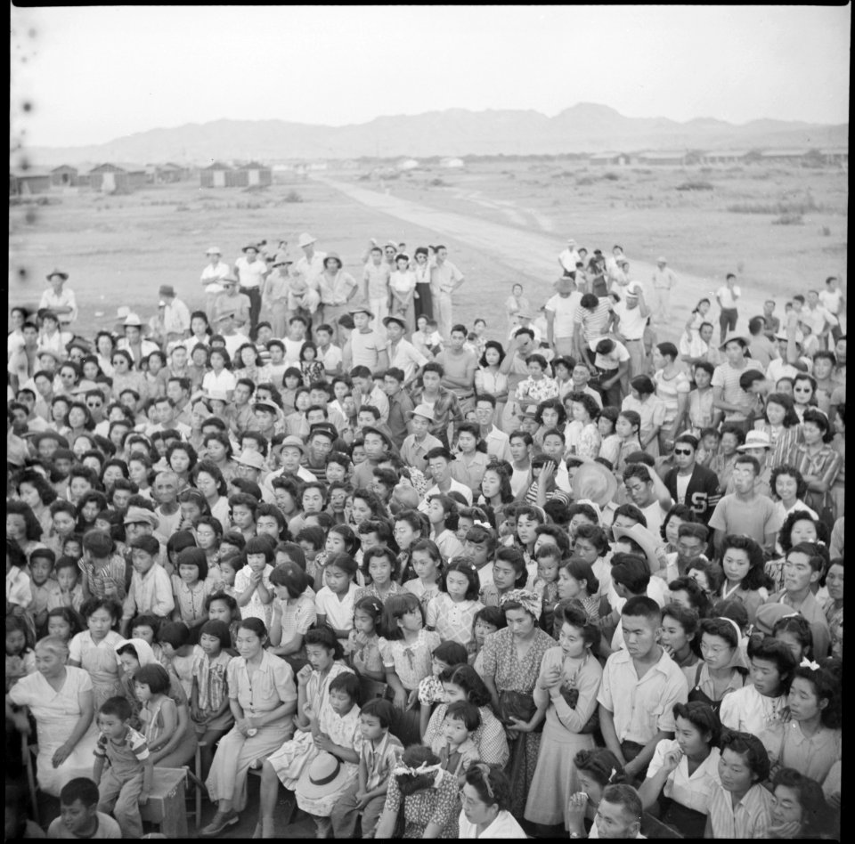 Poston, Arizona. A group of interested spectator evacuees watch an outdoor musical and dramatic sho . . . - NARA - 538564