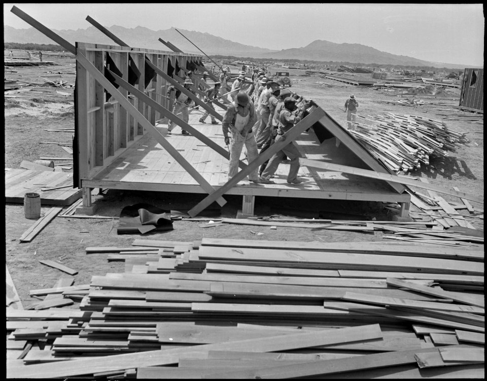 Poston, Arizona. Another side goes up in the construction of this barracks for living quarters for . . . - NARA - 536296