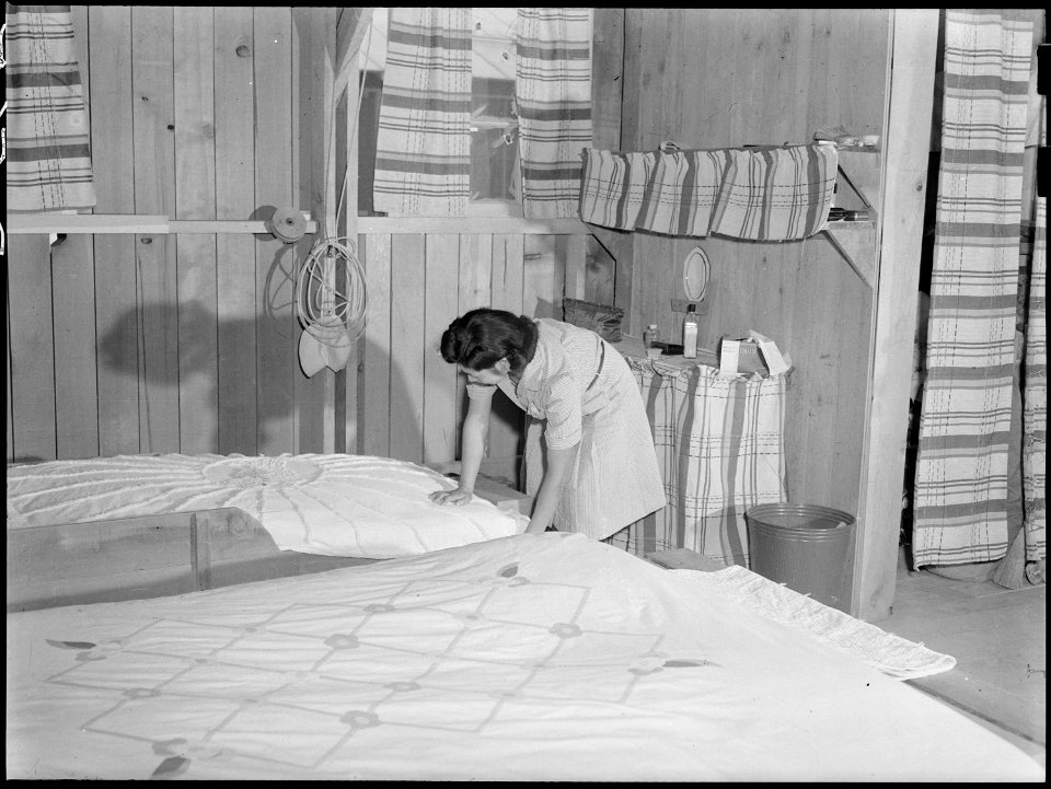 Poston, Ariozna. Mrs. Iwasaki tidies up her home at this War Relocation Authority center. Her fami . . . - NARA - 538530