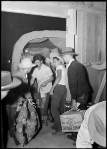 Poston, Arizona. Baggage belonging to evacuees of Japanese ancestry is delivered to their barracks . . . - NARA - 536289 photo