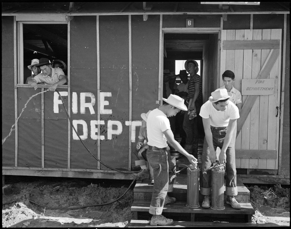 Poston, Arizona. Army type fire extinguishers are being examined by evacuees Eiichi Omori and Georg . . . - NARA - 536094