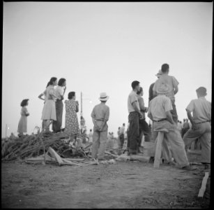 Poston, Arizona. Evacuees of Japanese ancestry watching performance at this War Relocation Authorit . . . - NARA - 538559 photo