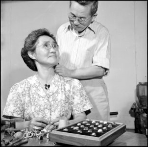 Poston, Arizona. Mr. Niseki tries one of his heart lockets on Mrs. Niseki. Although most of the sk . . . - NARA - 539885