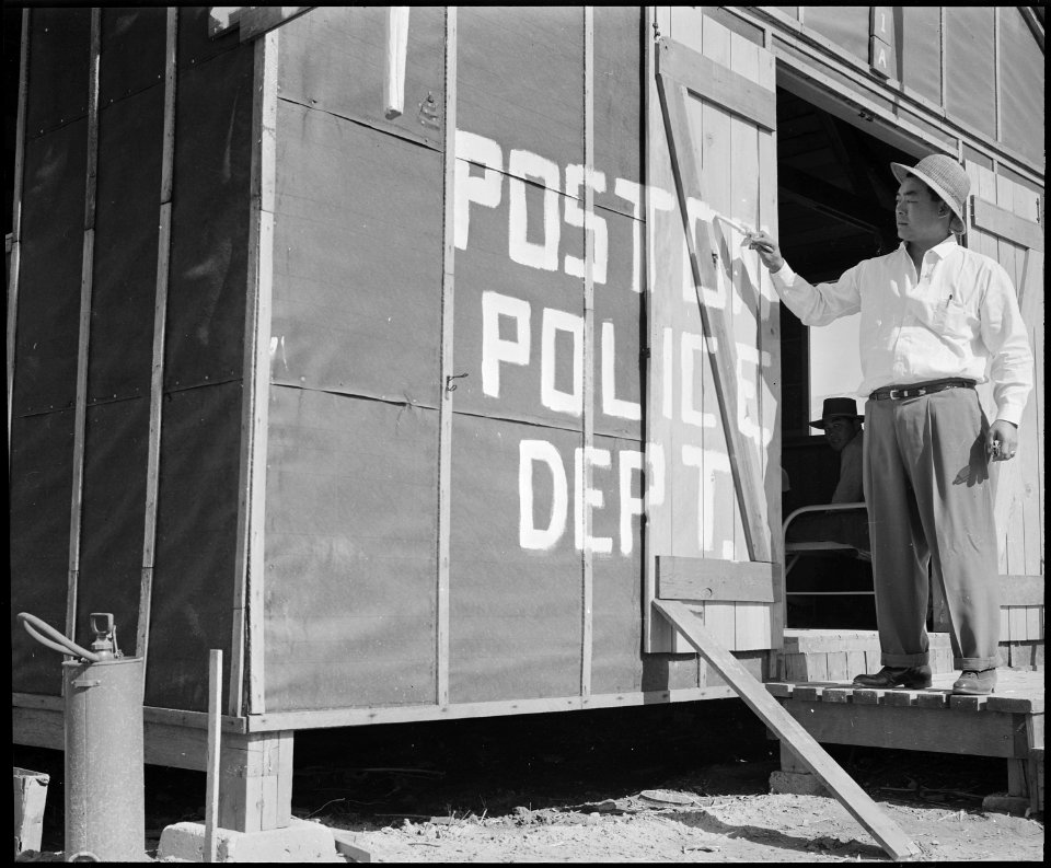 Poston, Arizona. Police chief Kiyoshi Shigekawn painting a sign on first police station at this War . . . - NARA - 536102