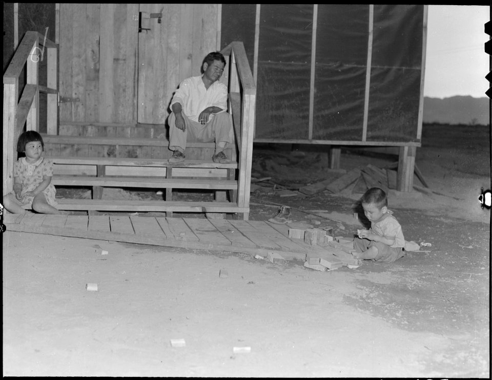 Poston, Arizona. Mosaru Oshio with his children on the steps of his barrack home at this War Reloca . . . - NARA - 536155