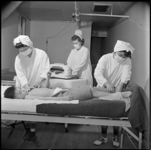 Poston, Arizona. Registered nurse, Mrs. Edythe Sasser, is assisted by Yoshiko Konatsu, nurse's aid, . . . - NARA - 537105