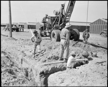 Poston, Arizona. Tom Nishimura watches workmen install fire hydrants at this relocation center for . . . - NARA - 536115