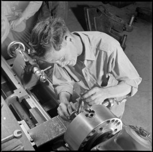 Poston, Arizona. Taketora Yamamoto, evacuee from Winslow, Arizona, is shown here at work in the mac . . . - NARA - 537116 photo