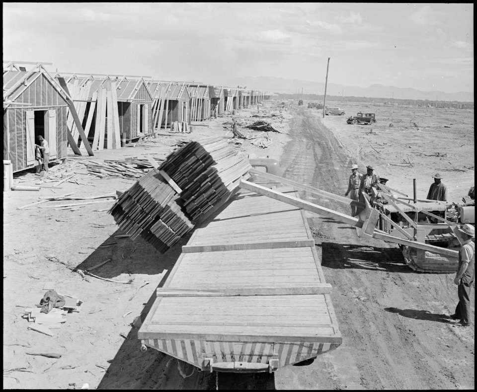Poston, Arizona. Unloading lumber with bulldozer in the construction of barracks for evacuees of Ja . . . - NARA - 536071