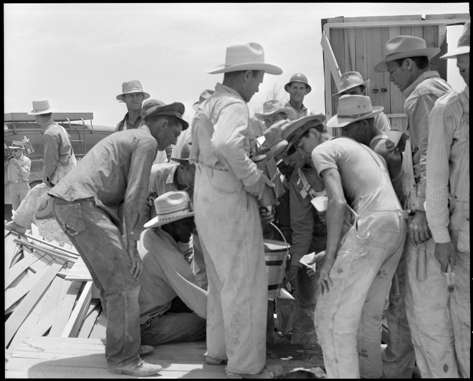 Poston, Arizona. Workmen getting drinks after record breaking erection of 16 buildings in 22 minute . . . - NARA - 536280